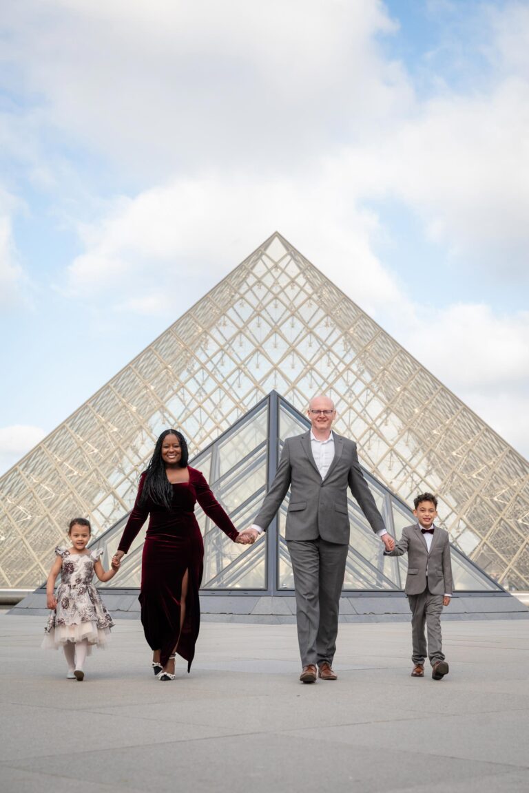 Family of four walking at the Louvre with pyramid during Paris family photoshoot