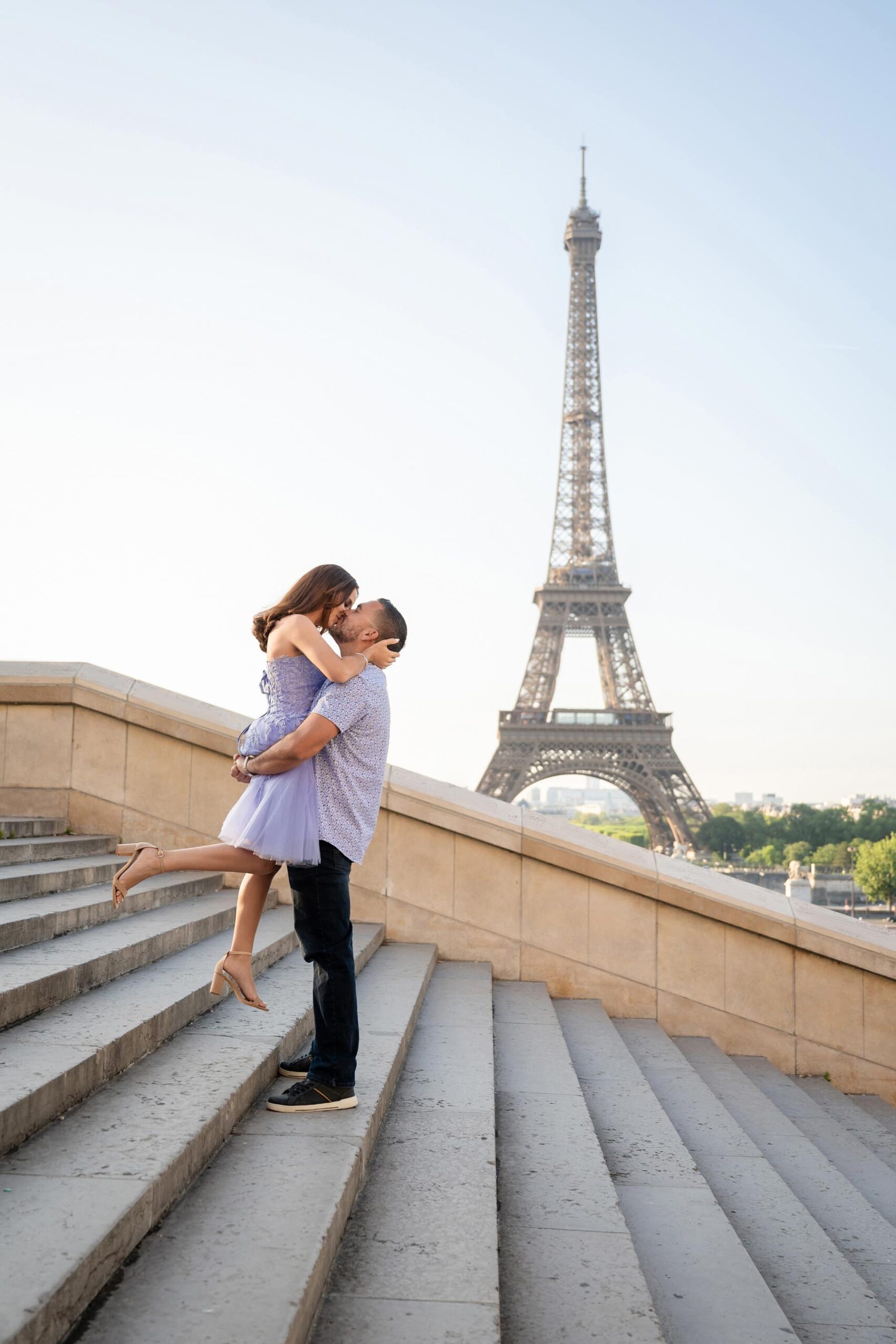 Elegant couple in purple outfits at Trocadéro stairs during Paris couple photoshoot