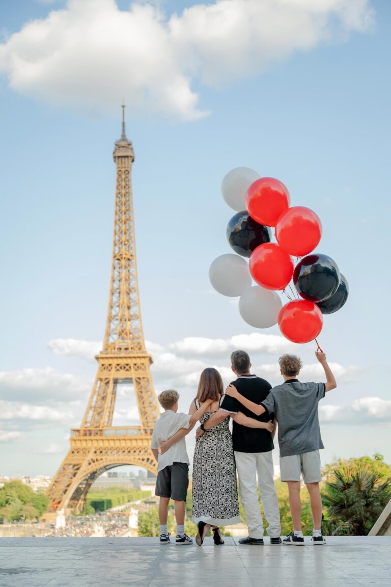 Happy family travel photo with Eiffel Tower and balloons
