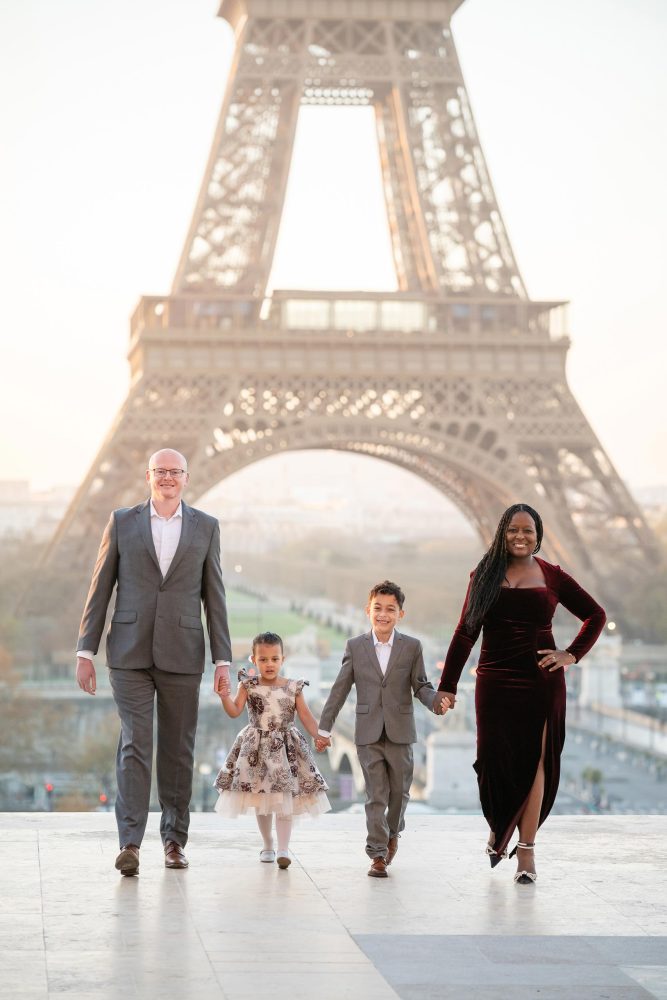 Family photo session at Eiffel Tower in Paris during a bright morning with parents and children