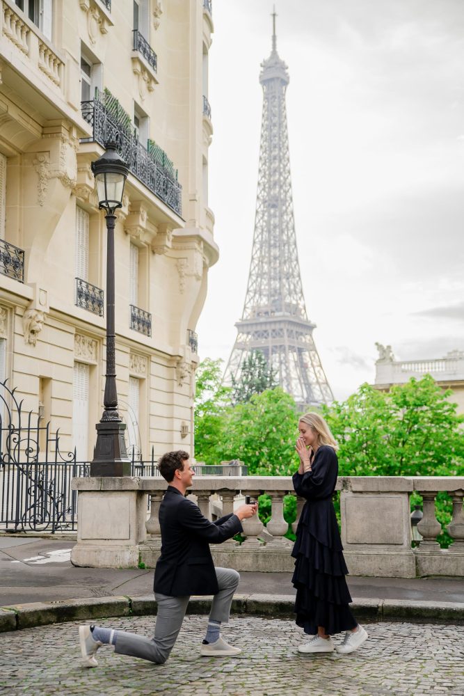 Surprise proposal near Eiffel Tower with man on one knee during Paris proposal photoshoot